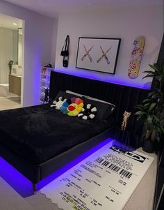 a bed that has some pillows on top of it in a room with purple lighting