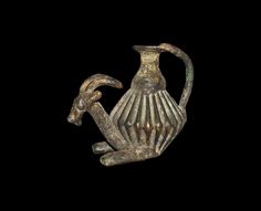 an old bronze figurine sitting on top of a black background