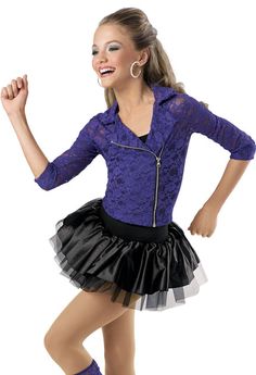 a woman in a purple top and black skirt is dancing with her hands on her hips