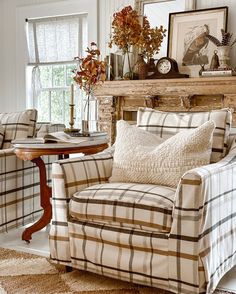 a living room filled with furniture and a fire place in front of a mantle covered in pictures