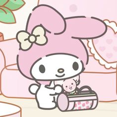 a hello kitty holding a baby in a pink outfit and sitting next to a teddy bear