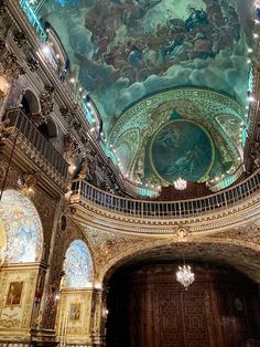 an ornately decorated auditorium with chandeliers and paintings on the ceiling