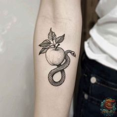 an apple and snake tattoo on the arm