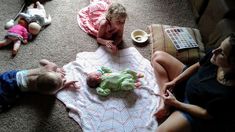 two women and a baby laying on the floor