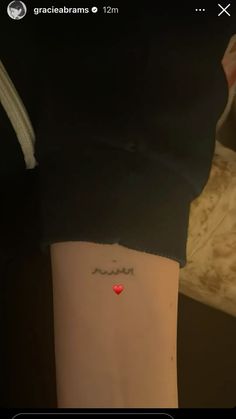 a person with a heart tattoo on their arm