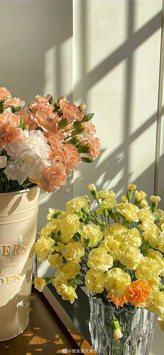 two vases filled with flowers sitting on a table