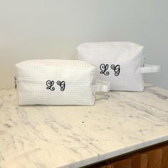 Add a touch of elegance to her daily routine with our Set of 2 Monogram Quilted Cosmetic Bags! Perfect for bridesmaids or as a thoughtful bridal shower gift, each bag is beautifully embroidered with her initials for a personalized touch. These versatile makeup cases are ideal for storing beauty essentials or as stylish toiletry bags for travel. Crafted with quilted fabric and attention to detail, they make for a chic and practical gift that she'll love. Make her special day even more memorable with our Monogram Quilted Cosmetic Bags! ITEM DESCRIPTION: > Sizes Large: 22.9cm x 10.2cm x 15.2cm Small:  20cm x 10cm x 8 cm > Please see the alphabet chart for the colourway for the letter that you have chosen. > This bag can be machine washed, so any spills or stains can be washed away. VISIT MY S Wedding Pouch, Thoughtful Bridal Shower Gifts, Quilted Cosmetic Bag, Monogram Cosmetic Bag, Monogram Quilt, Makeup Cases, Gifts For Swimmers, Monogrammed Napkins, Bride And Groom Gifts