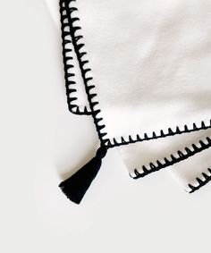 two white towels with black tassels on them