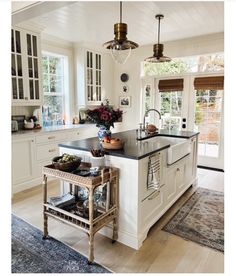 a large kitchen with an island in the middle and lots of cabinets on both sides