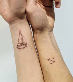 two people with matching tattoos on their arms, one has a sailboat and the other has an anchor