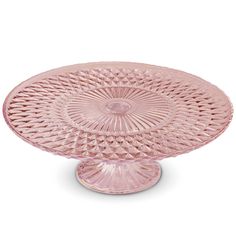 a pink glass cake plate sitting on top of a table