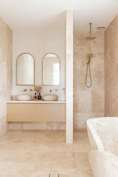 a large bathroom with two sinks and a bathtub in the middle of the room