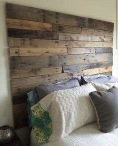 a bed with wooden headboard made from pallet wood and pillows on top of it