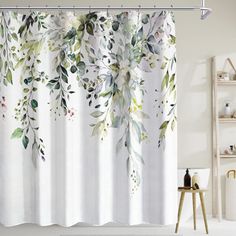 the shower curtain is decorated with watercolor flowers and leaves on white fabric, along with a wooden stool in front of it