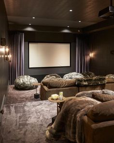 a home theater with two couches and a projector screen in the middle of the room