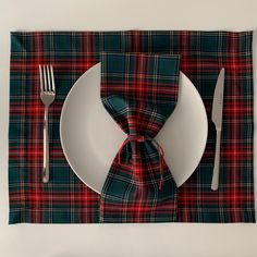 a place setting with a plaid napkin and fork, knife and spoon on the plate