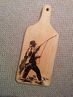 a wooden tag with an image of a man fishing