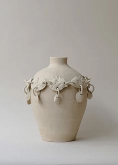 a white vase sitting on top of a table