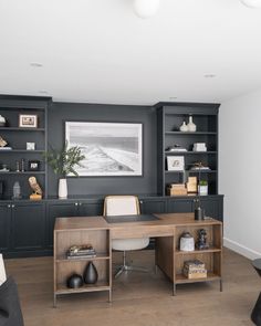 a home office with built in bookcases and shelves