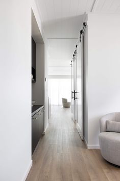 an empty room with white walls and wood floors is seen in this image from the hallway