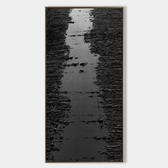 a black and white photo of water on the beach with footprints in the wet sand