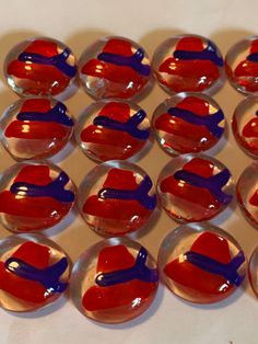 red, white and blue glass marbles are arranged in a pattern on a table