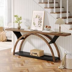 a wooden table sitting on top of a hard wood floor next to a stair case