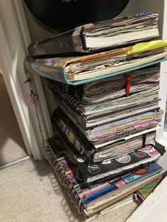 a stack of magazines sitting on top of a floor next to a clock and door