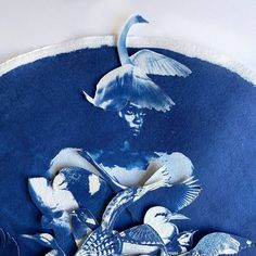 a blue and white painting with birds on it's face, in the middle of an image of a woman surrounded by other birds