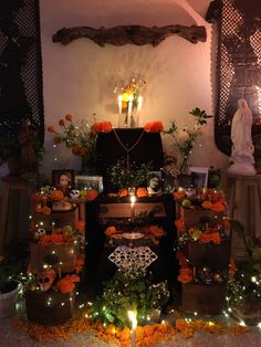 an altar with candles, flowers and pictures on it