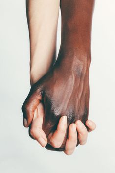 two hands holding each other in front of a white background