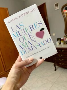 a person holding up a book in front of a mirror with the title las muerres que aman demasndo