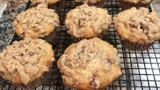 several muffins cooling on a wire rack in the kitchen, some with crumbs