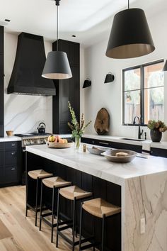 Modern kitchen with black accents including pendant lights, cabinetry, and bar stools. Black And White Kitchen Ideas Modern, Black Kitchen Counter, Moody Kitchen Design, Casita Kitchen, Black Ceilings, Black And White Kitchen Ideas, Black Kitchen Inspiration, Modern Eclectic Kitchen, Black Light Fixtures