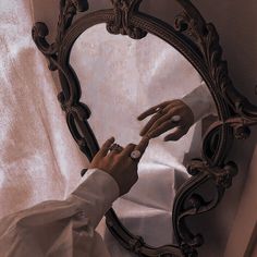 a woman is touching her hand in front of a mirror