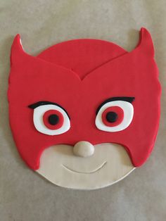 a close up of a cake with a devil mask on it's face and eyes