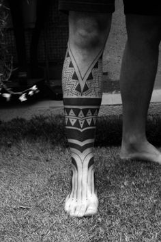 the legs and ankles of a person with tattoos on their feet, in black and white