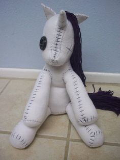 a white stuffed animal sitting on top of a tiled floor