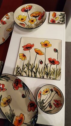 a table topped with plates and bowls covered in floral designs next to each other on top of a white surface