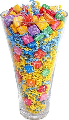 a glass filled with lots of colorful candies