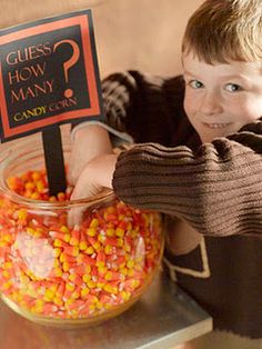 a person holding up a sign next to a bowl of candy