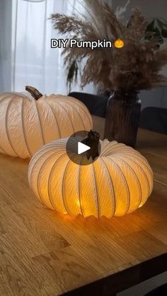 two white pumpkins sitting on top of a wooden table