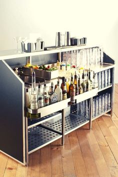 a bar with many bottles and glasses on it's shelves in the middle of a room