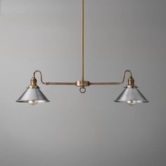 three lights hanging from a ceiling fixture in a room with gray walls and flooring