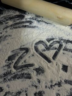 the word love spelled out in flour next to a rolling pin