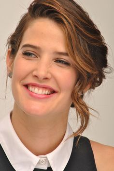 a smiling woman wearing a white shirt and black tie