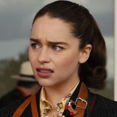 a woman wearing a suit and tie with an odd look on her face