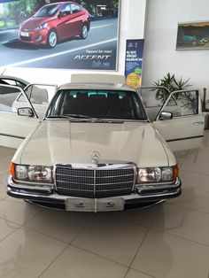 the front end of a white car in a showroom