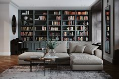 a living room filled with lots of bookshelves next to a couch and coffee table