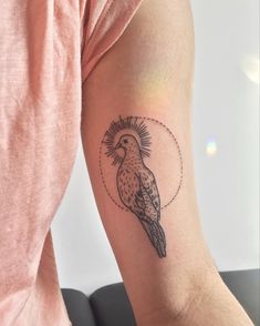 a small bird tattoo on the arm